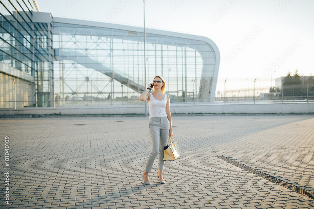 Business woman using a phone while standing in outdoor Business woman using a phone while standing in outdoor