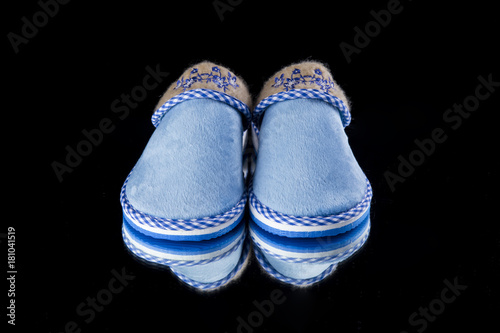 Female Blue Slipper on Black Background, isolated product, comfortable footwear.