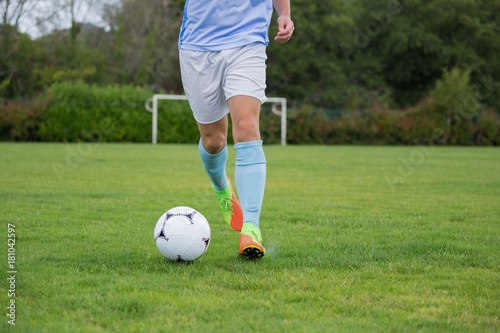 Football player dribbling the soccer