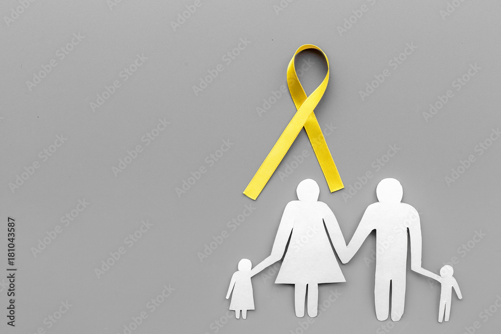 Yellow ribbon for suicide and endometriosis awareness near paper silhouette of family on grey background top view copyspace Yellow ribbon for suicide and endometriosis awareness near paper silhouette of family on grey background top view copyspace