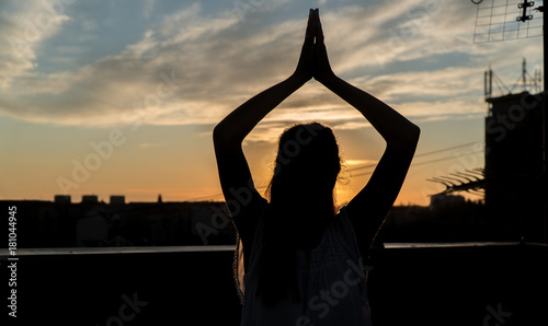 Rooftop meditation silhouette of a woman in sunset