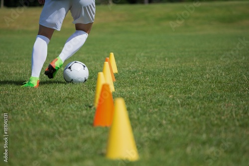 Soccer player dribbling through cones