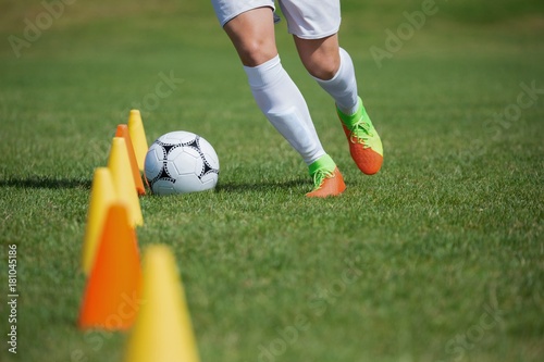 Soccer player dribbling through cones