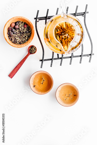 Tea ceremony concept. Tea pot, cups or bowls, dry tea leaves on white background top view copyspace