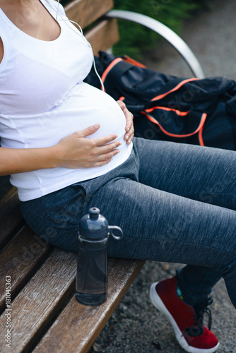 Close up of sporty pregnant woman belly. Pregnancy fitness and healthy lifestyle concept.