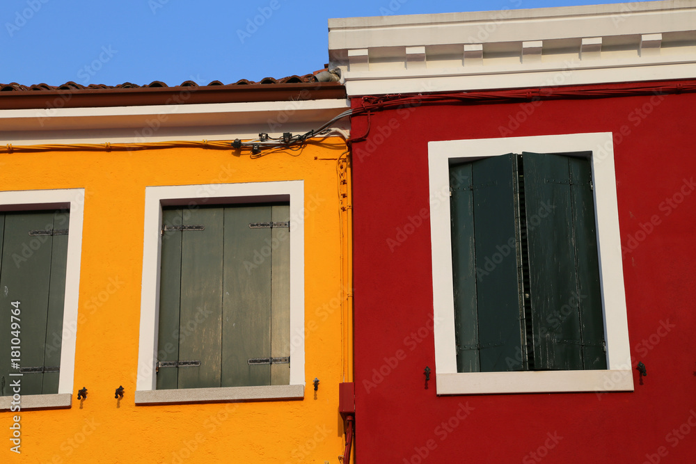 Fototapeta premium house with painted yellow and red wall and closed windows