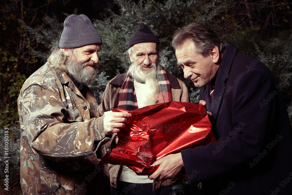 Two homeless older men rewarding manager man for gift of food