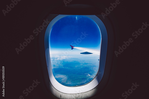 Looking through window aircraft during flight in wing blue sky.