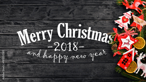 Christmas background with Christmas tree and Christmas tree decorations, and Merry Christmas and Happy New Year 2018 text on wooden background.