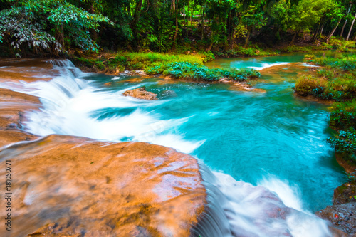 Fototapeta Naklejka Na Ścianę i Meble -  Than sawan Waterfall, Payao, Thailand, Long explosure shot, Beautiful green waterfall in the nature at sunset.