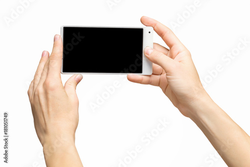 Mockup of female hands holding white frameless cellphone with black screen and making selfie at isolated background.