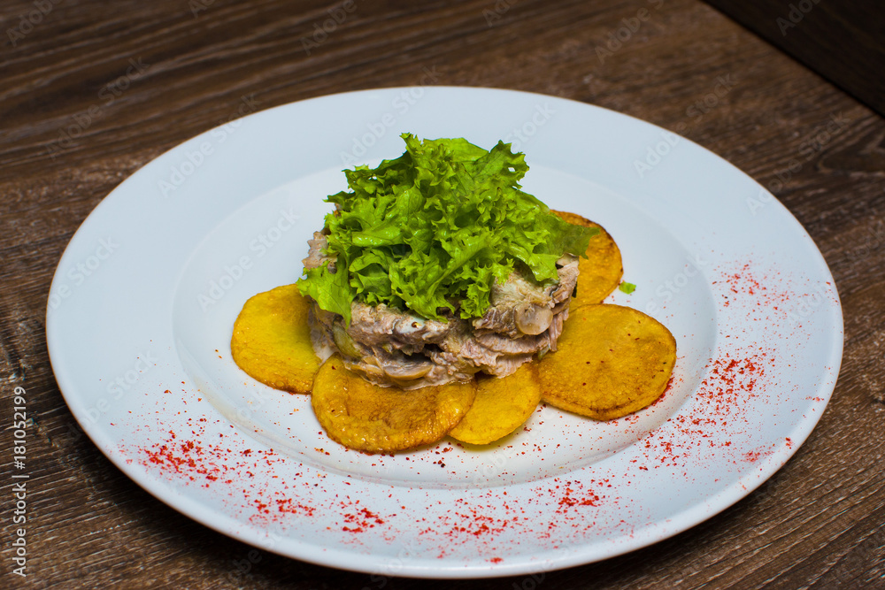 fried potatoes with salad on a plate