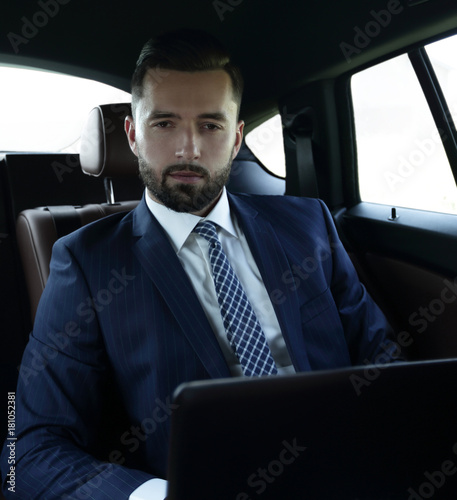 businessman with laptop sitting in a comfortable car © ASDF