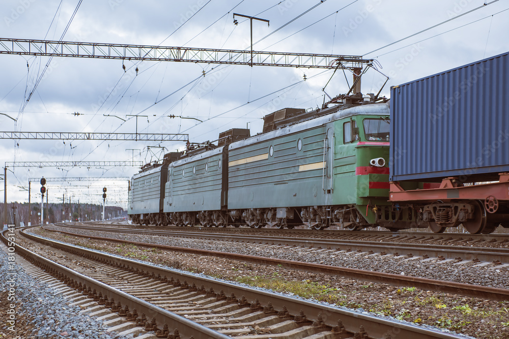 The locomotive of a freight train drags the composition of containers on platforms of a railway track. The locomotive of a freight train drags the composition of containers on platforms of a railway track.