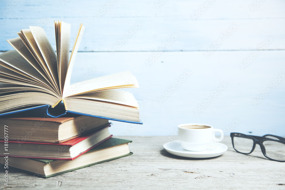 Fototapeta premium books and cup of coffee on wooden table