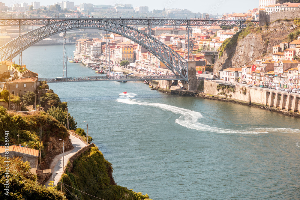 Landscpe view on the Douro river with speedboat floats and beautiful iron bridge in Porto city, Portugal