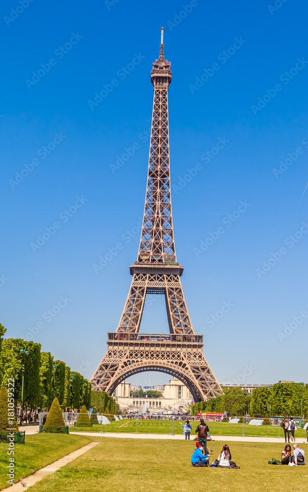 Eiffel Tower in Paris, with grass lawn and people. Paris, France