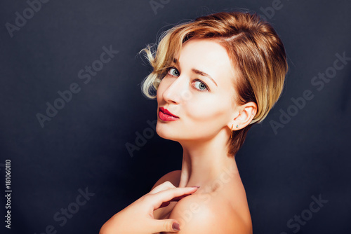 Blonde girl with a short stylish haircut on a dark background 