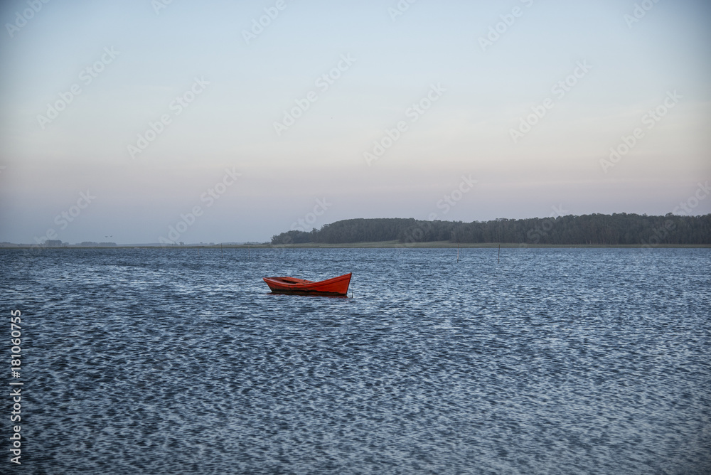 Canoa roja en lago azul
