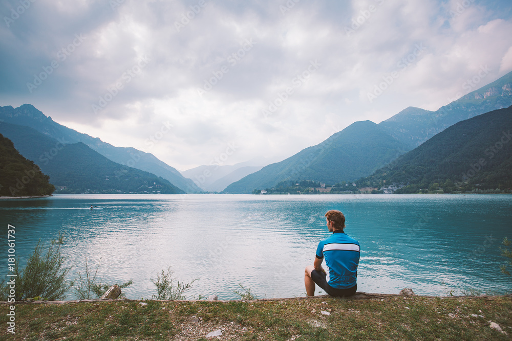 tourist cyclist rests near the mountain lake Lago di Ledro in Italy in the vicinity of lago di Garda