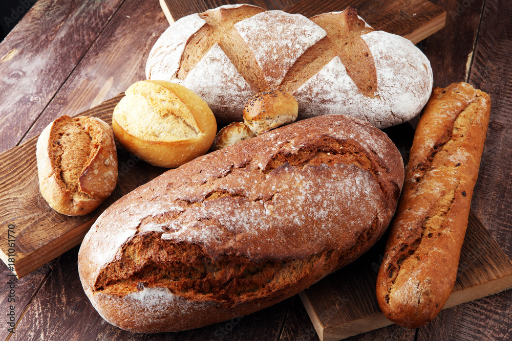 bakery concept with bread and bread rolls on wooden background.