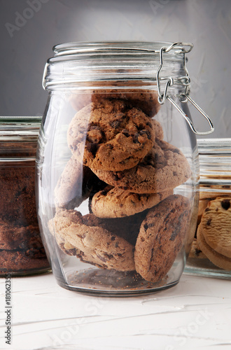 Fototapeta Chocolate cookies in a glass jar on white background.