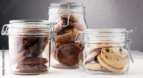 Fotografering Chocolate cookies in a glass jar on white background.