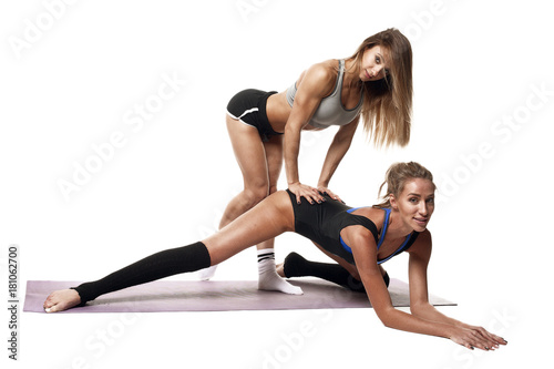 two beautiful fitness girls made stretching isolated