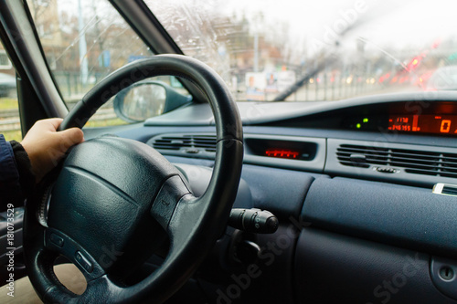 Man hand on steering wheel driving car. © Voyagerix