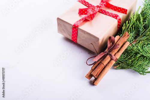 Gift, cinnamon and green branch of spruce isolated on white background photo