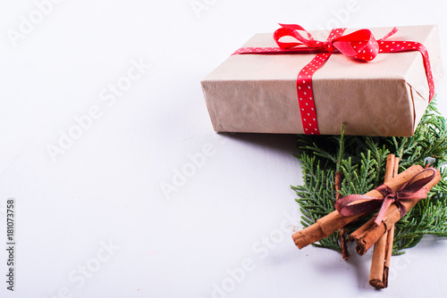 Gift, cinnamon and green branch of spruce isolated on white background photo