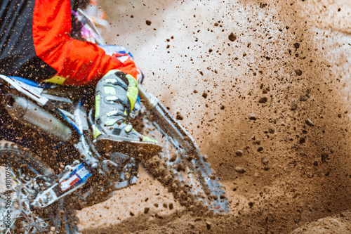 Foto Details of flying debris during an acceleration with mountain bikes race in dirt track in sunshine day time in blurry background