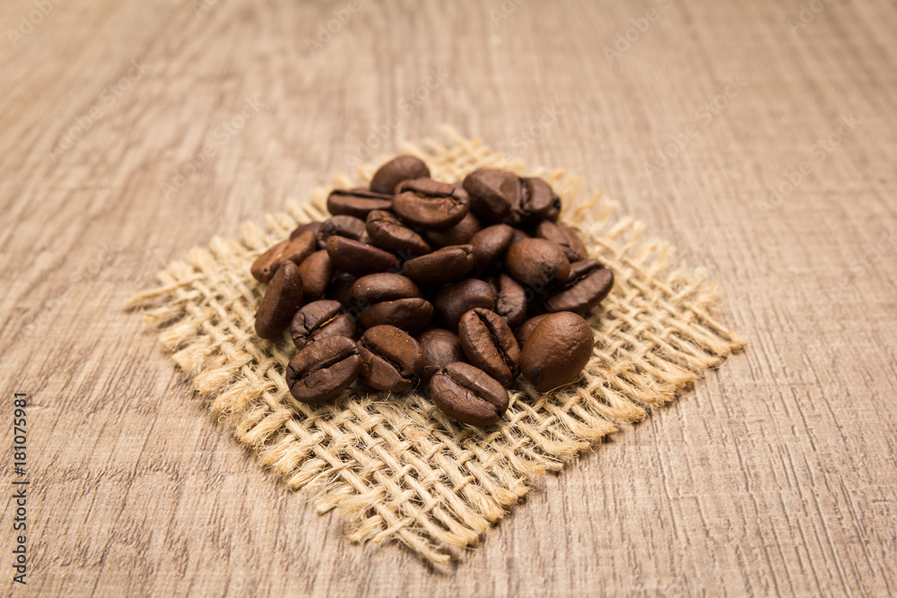 coffee beans seed. Grains on square cutout of jute. Wooden table. Selective focus. coffee beans seed. Grains on square cutout of jute. Wooden table. Selective focus.