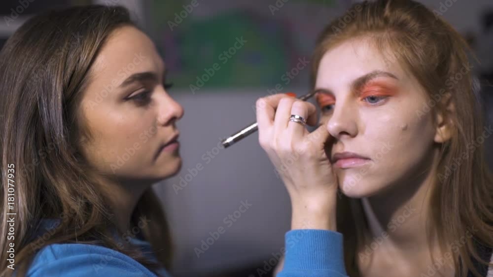 Makeup artist making make-up for a beautiful young woman at home Makeup artist making make-up for a beautiful young woman at home