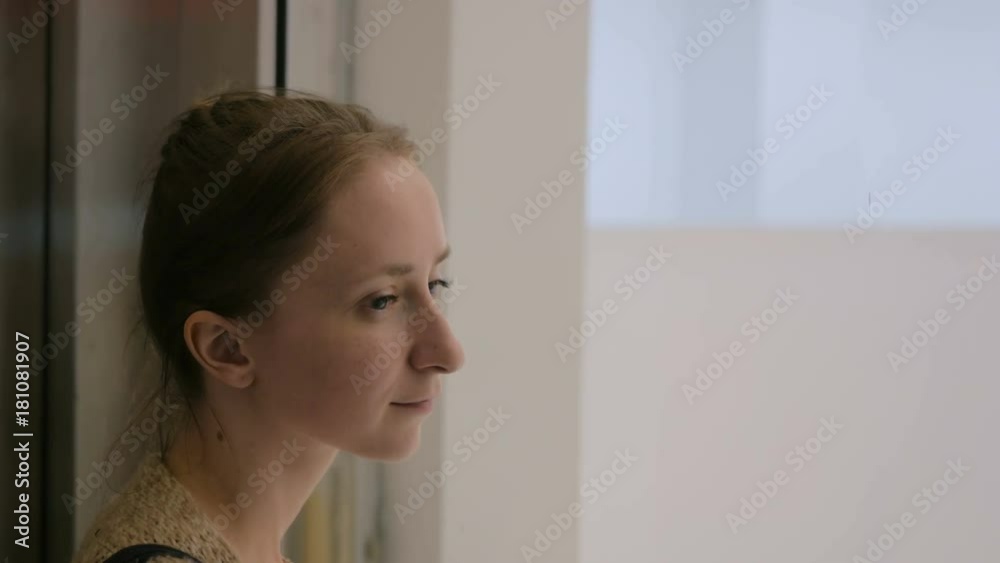 Young woman looking around in elevator, which moving down Young woman looking around in elevator, which moving down