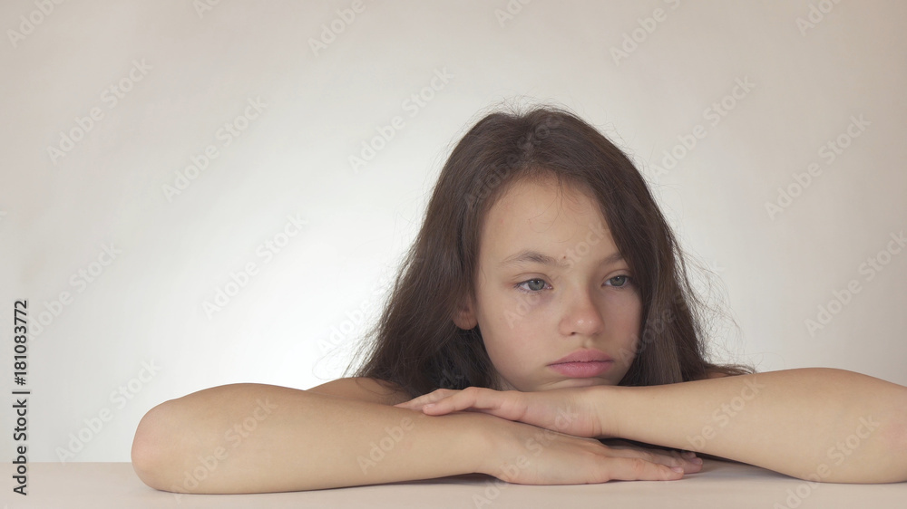 Beautiful sad teenage girl expresses resentment and sadness on white background Beautiful sad teenage girl expresses resentment and sadness on white background