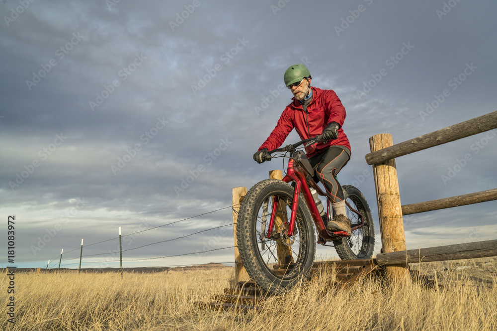 Obraz premium riding a mountain fat bike over cattle guard