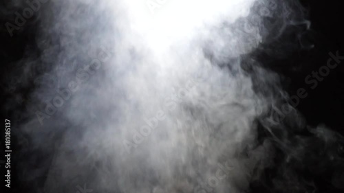 White smoke rises into the night on a black background