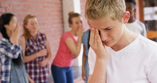 School friends bullying a sad boy in school premise  photo