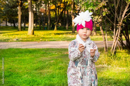 Autumn portrait of beautiful child. Happy little girl with leaves in the park in fall.