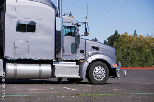 Profile of Big rig gray classic semi truck tractor going to delivery commercial cargo