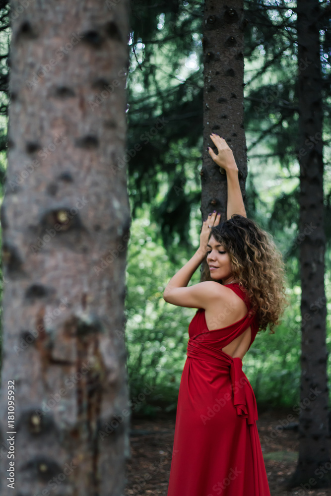 girl in the woods in red dress making pose girl in the woods in red dress making pose