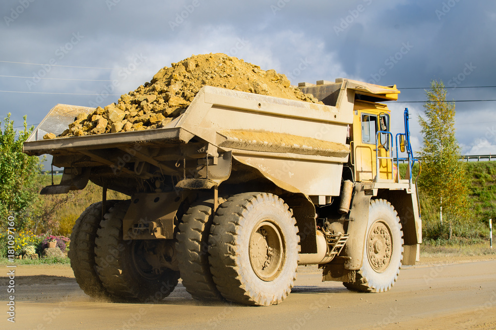 Extraction of minerals. Big yellow mining truck transporting materials