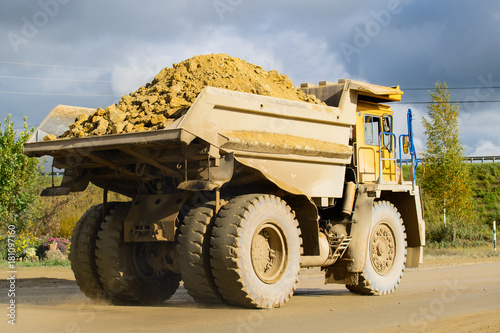 Extraction of minerals. Big yellow mining truck transporting materials