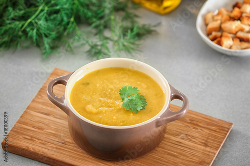 Board with tureen of homemade lentils creme soup on table photo