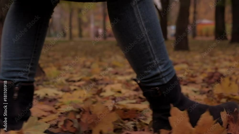 Camera follows beside boots of woman walking through autumn leaves. Shot in real time on a gimbal Camera follows beside boots of woman walking through autumn leaves. Shot in real time on a gimbal