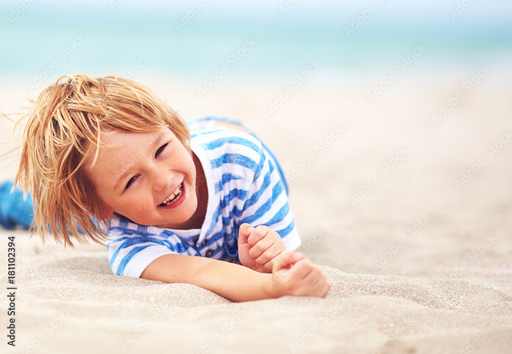 cute happy laughing boy, kid having fun on sandy beach, summer vacation cute happy laughing boy, kid having fun on sandy beach, summer vacation