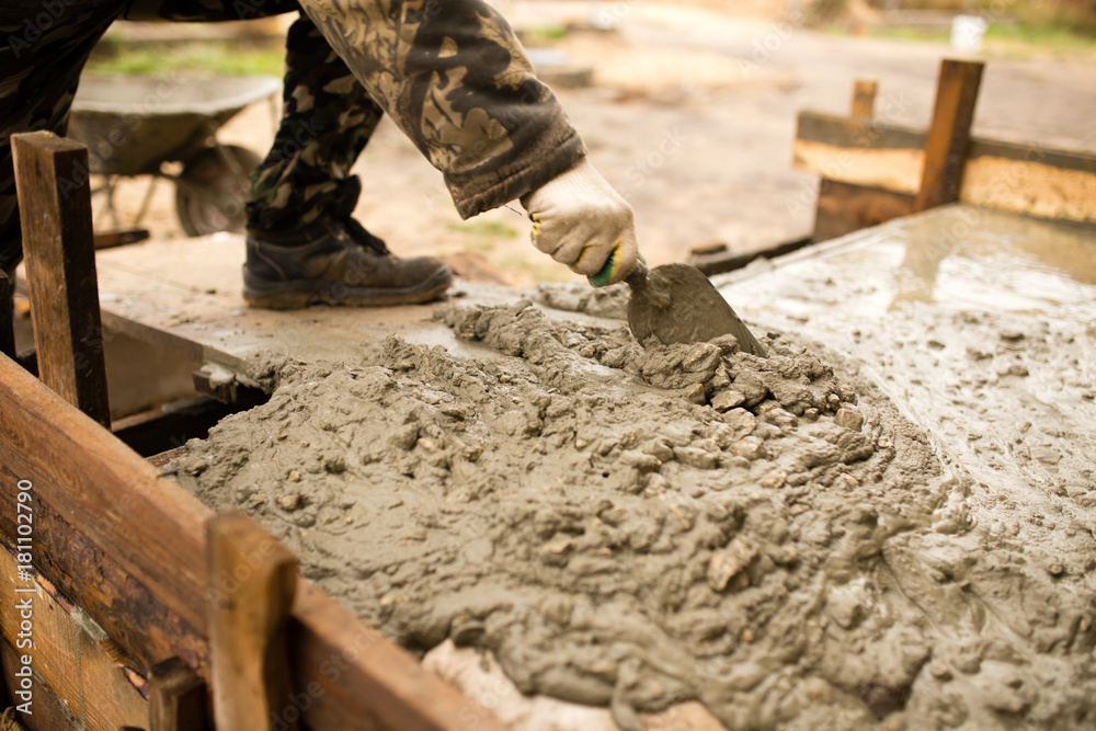 worker pours concrete mortar on a construction site