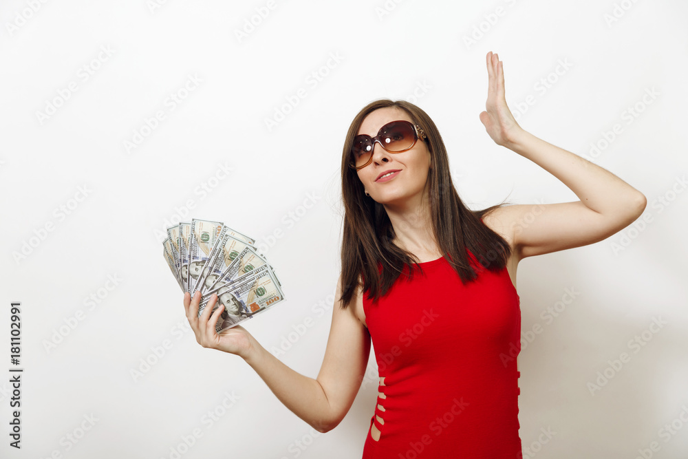 Pretty caucasian young happy business woman in red fitting dress and glasses holding money banknotes on white background. Beautiful girl with cash looking aside isolated. Pretty caucasian young happy business woman in red fitting dress and glasses holding money banknotes on white background. Beautiful girl with cash looking aside isolated.