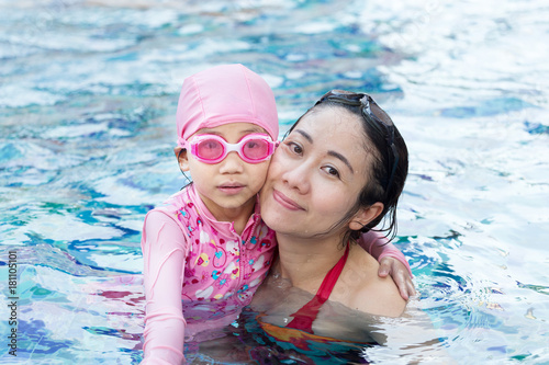 Smiling beautiful woman and little girl in a swimming pool © thechatat